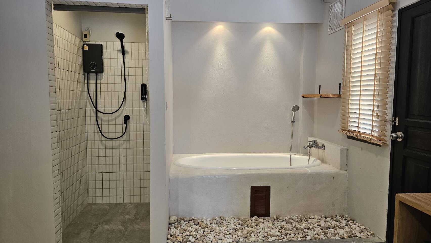 Un baño con ducha, bañera y ventana con persianas.