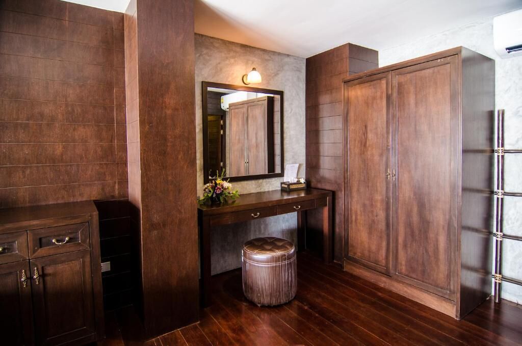 A bathroom with a wooden vanity, a mirror, and a cabinet.