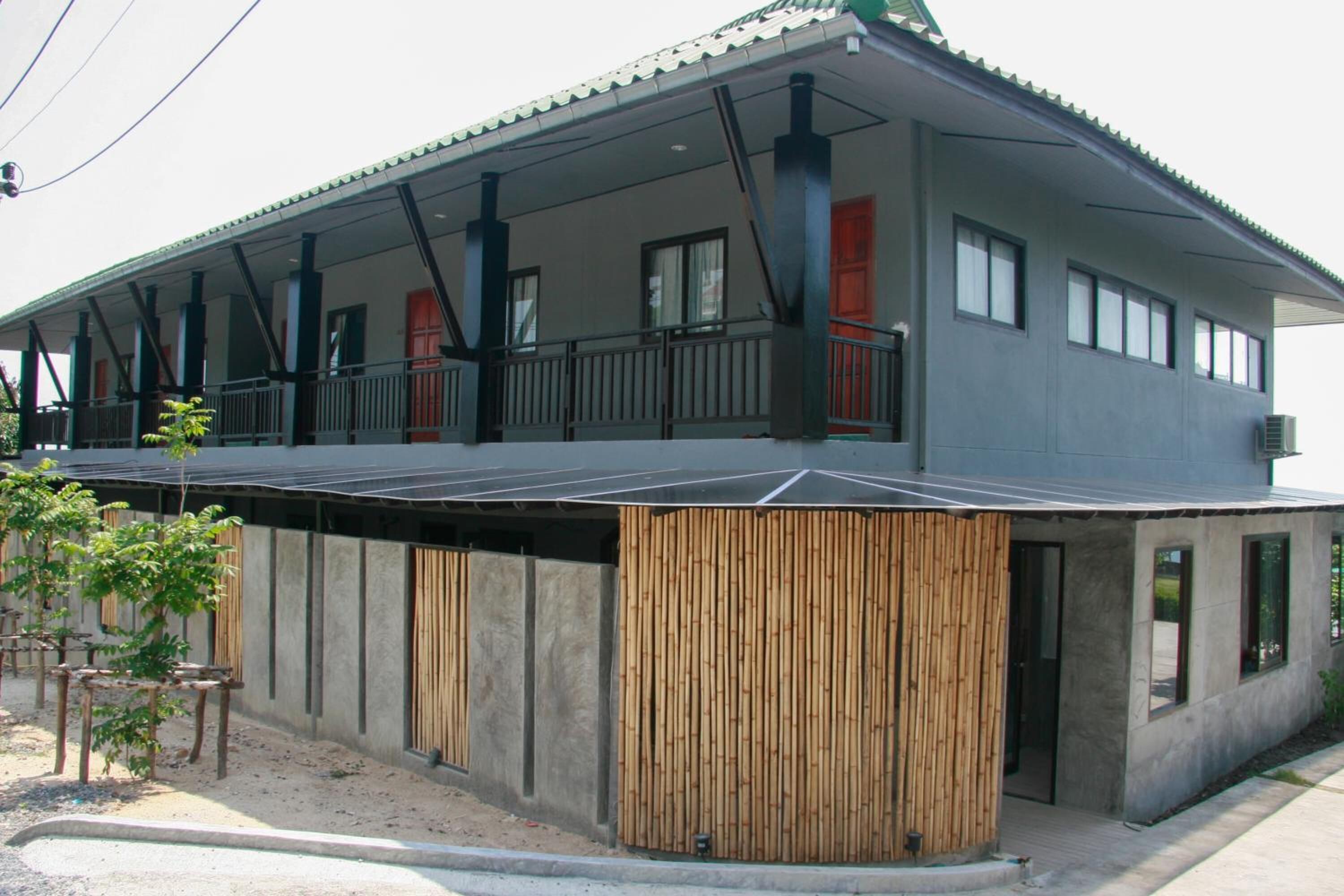 Um edifício moderno com telhado plano, amplas janelas e área externa coberta.