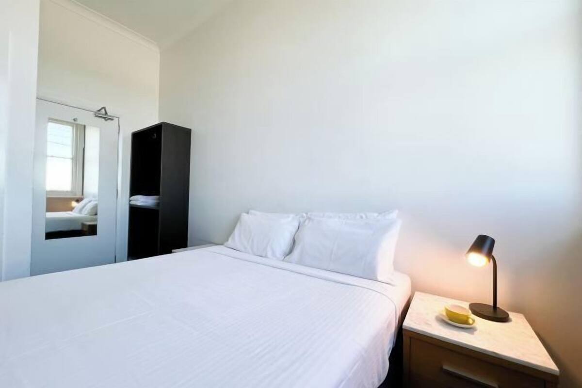 Escritorio, cortinas blackout y tabla de planchar con plancha