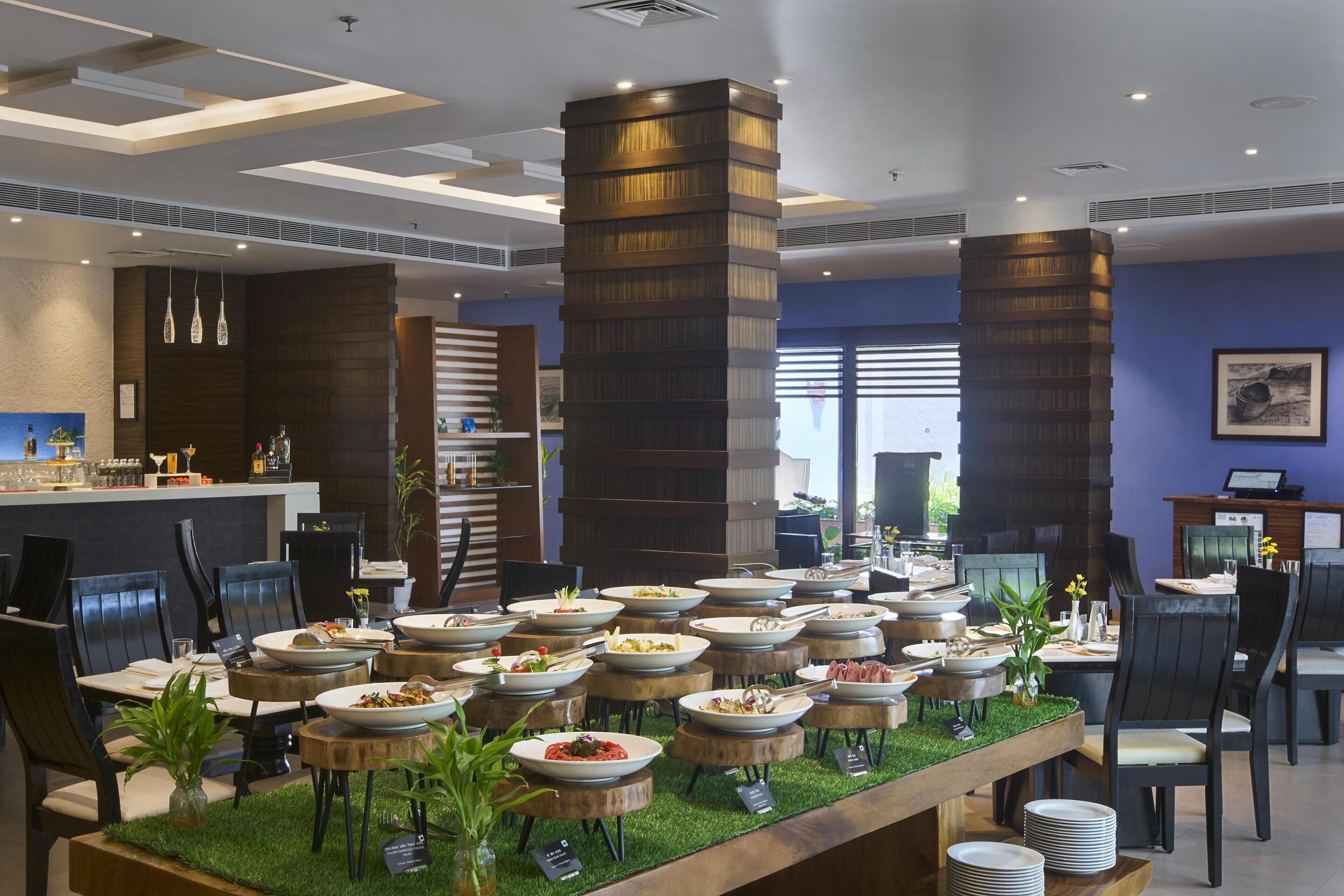 A buffet setup with multiple serving stations, a bar area, and seating arrangements.