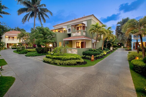 A two-story hotel with a courtyard, palm trees, and well-maintained gardens. - Radisson Blu Resort Goa Cavelossim Beach (Cavelossim)