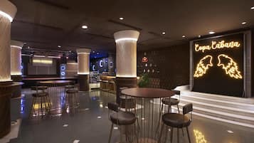 Ein modernes Interieur mit runden Tischen und Barhocker, einer Neonreklame mit der Aufschrift "Copa Cabana" und einer Sitzecke mit gemustertem Wanddesign und Blumentöpfen.