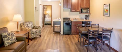 A compact living space with a kitchenette, a dining area, and a bedroom.