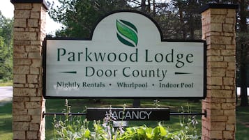 Señal de Parkwood Lodge en Door County que anuncia alquileres por noche, un hidromasaje y una piscina interior.