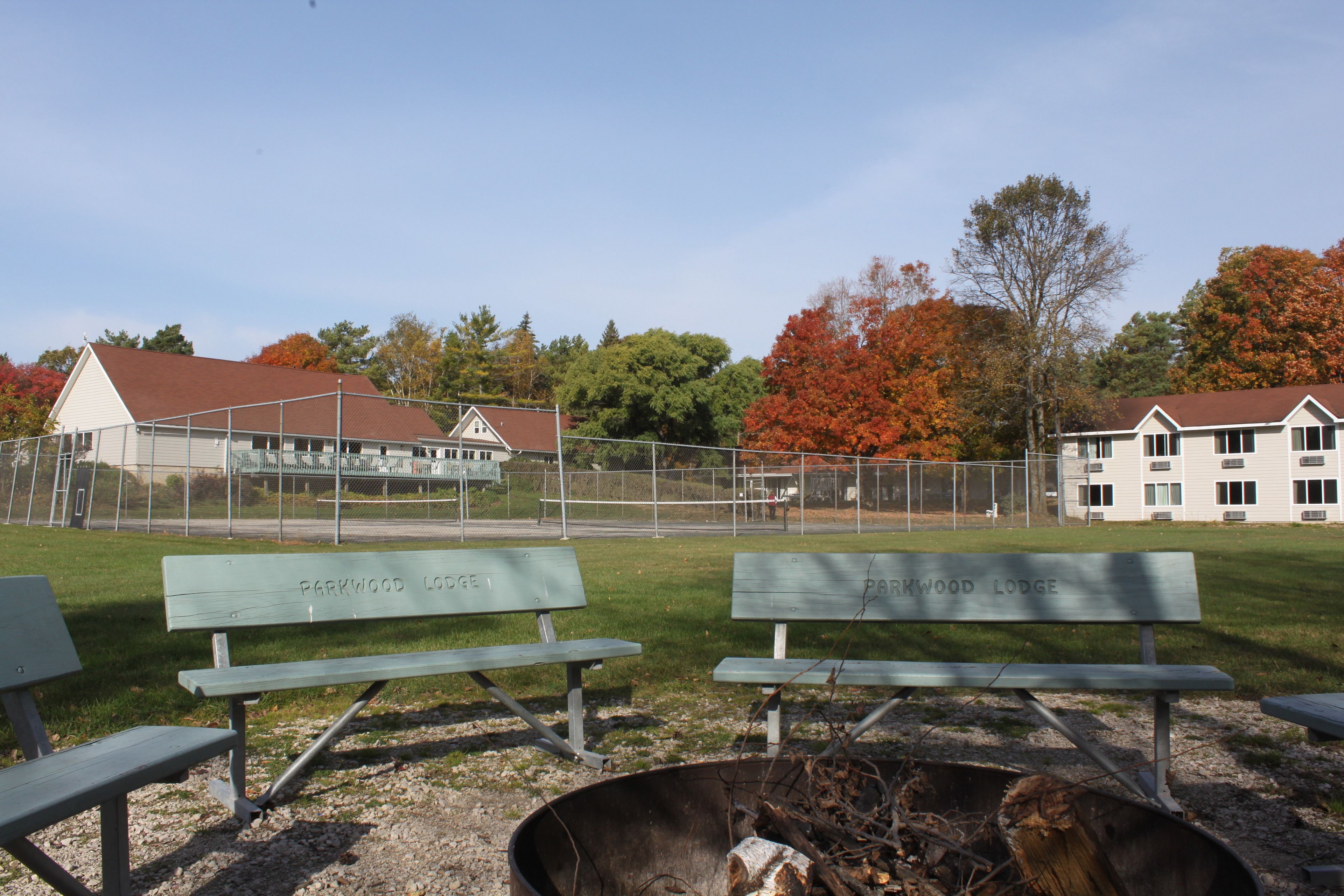 A park with benches labeled "Parkwood Lodge" and a fire pit area.