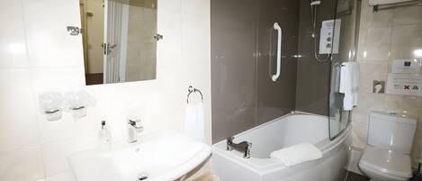 A modern bathroom with a white sink, a bathtub, and a toilet.
