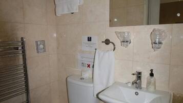 A bathroom with a toilet, sink, and a towel rack.