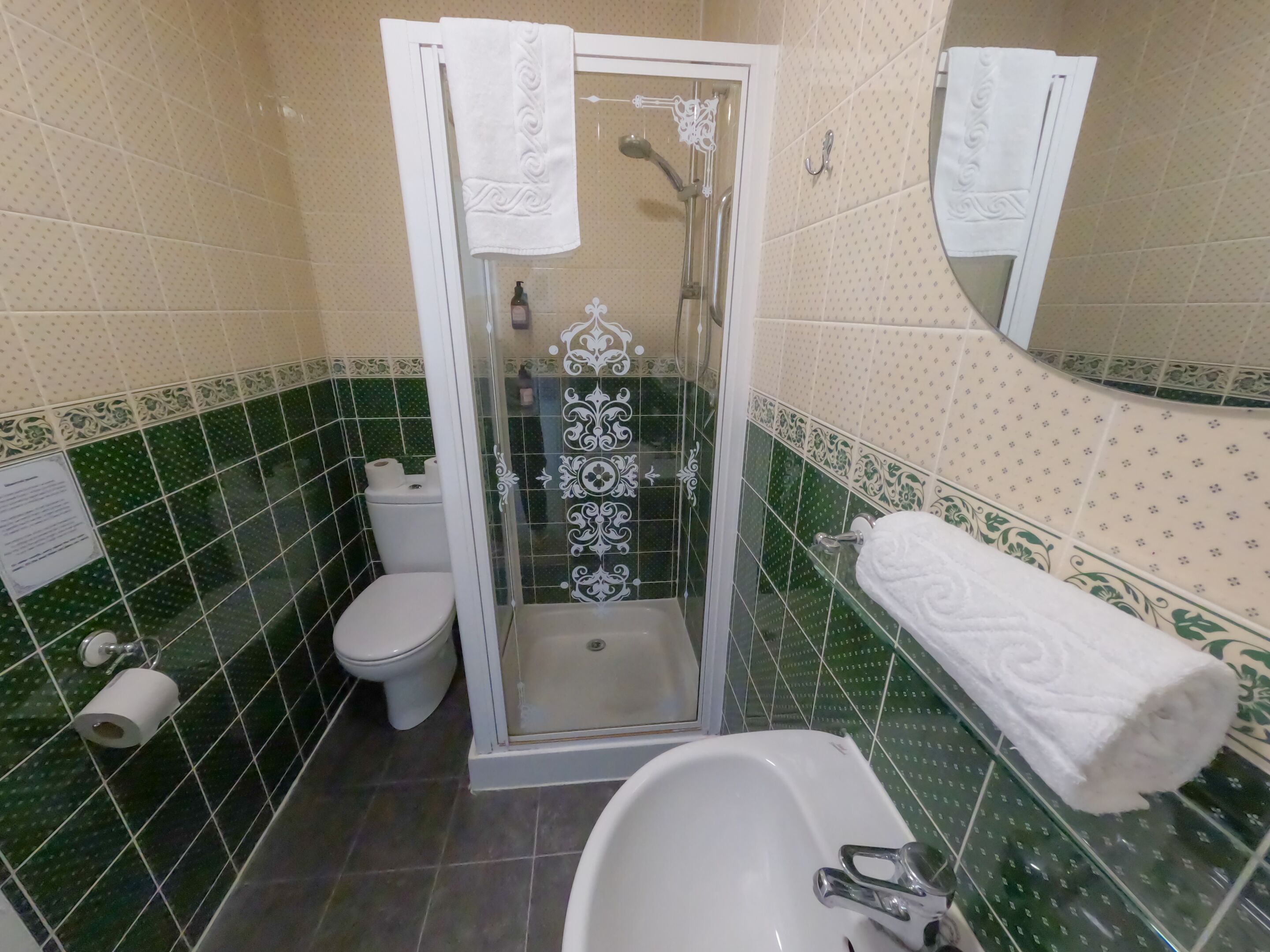 A bathroom with a shower, toilet, and sink.