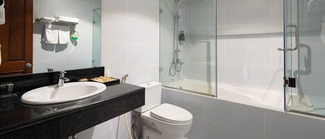Un baño moderno con ducha acristalada, inodoro blanco y encimera negra con lavabo.