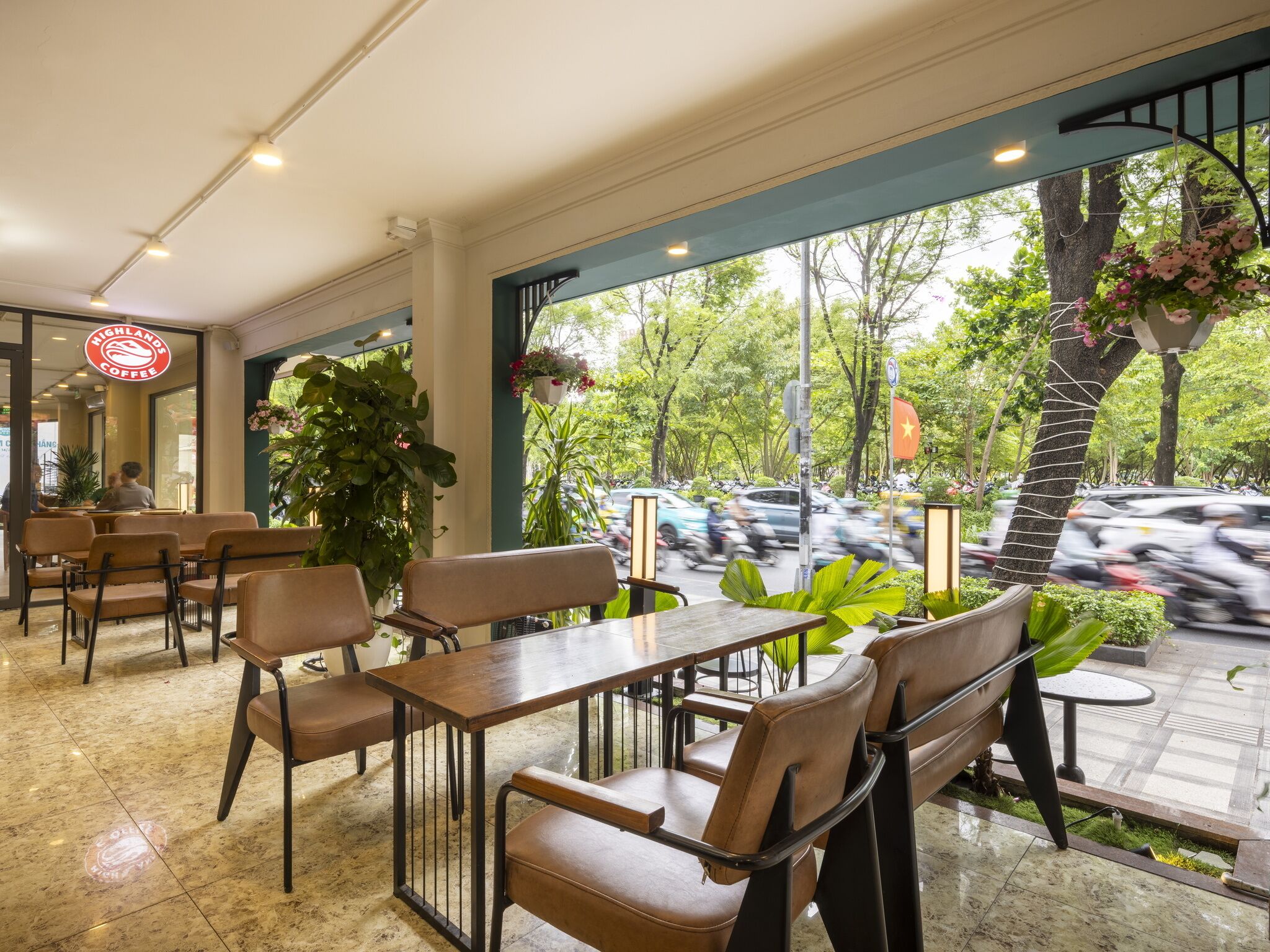 A cafe with indoor seating, large windows, and a view of the street.