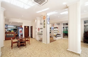 Un vestíbulo amplio con una zona de estar central, una recepción y una tienda de cuero 2DO.
