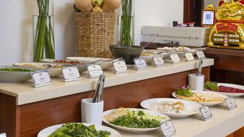 A buffet with various dishes labeled, including green onions, crispy fried shallots, and a salad with bean sprouts.