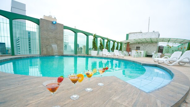 A rooftop pool with clear blue water, surrounded by white lounge chairs and a bar area. - Hotel Nacional Inn Curitiba Estação Shopping (Curitiba)