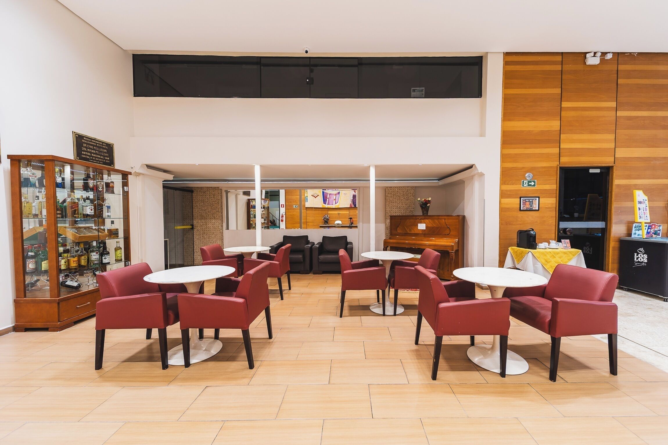 Un hall d’entrée spacieux comprenant plusieurs espaces de détente, un comptoir d’accueil et un bar à boissons.