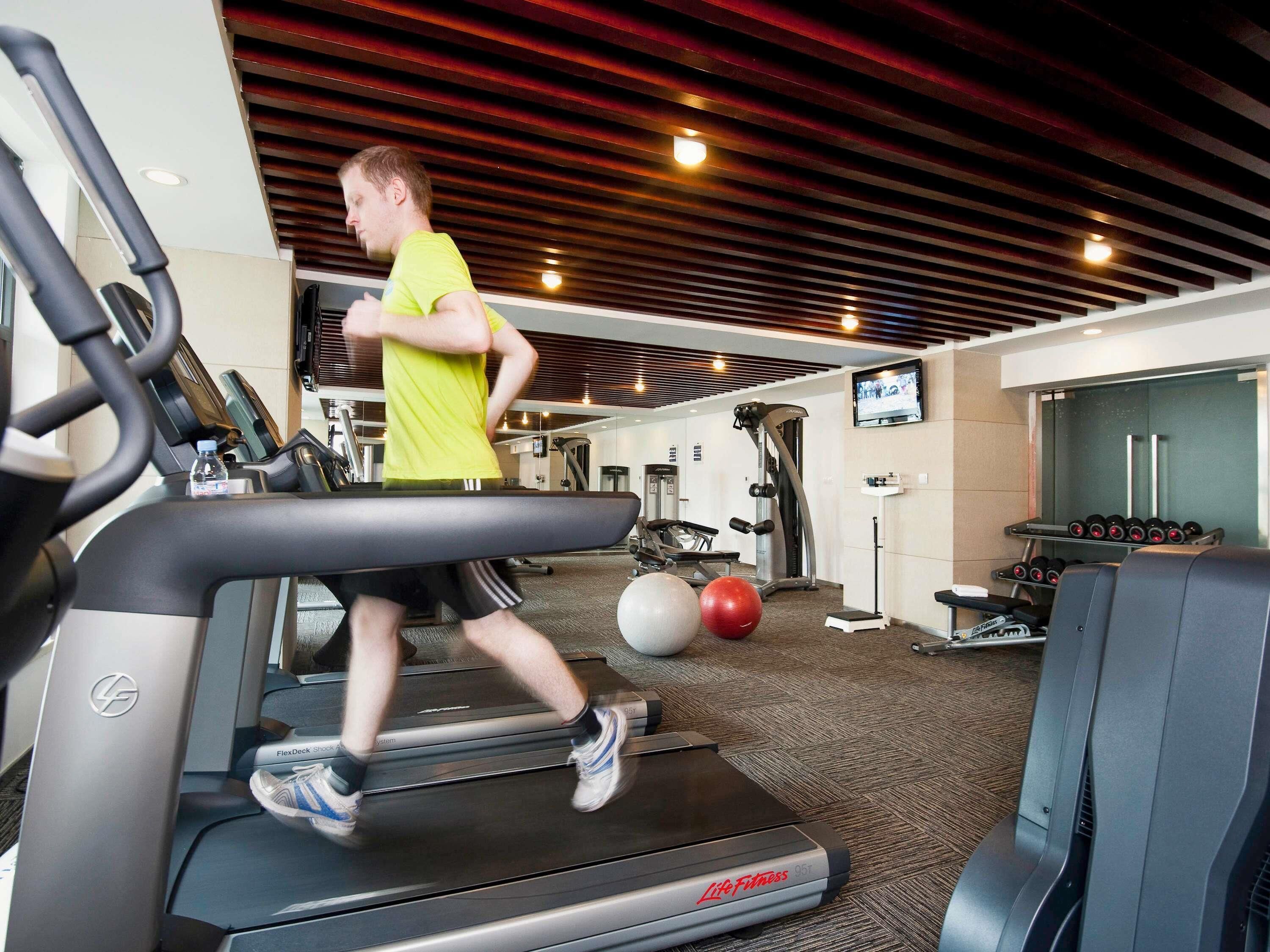 Ein Fitnessraum mit Laufbändern, einem Ergometer und einer Gewichtbank.