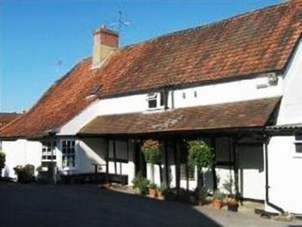 A traditional white building with a tiled roof and a covered porch area.