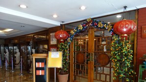 A reception area with a welcome sign, a display case, and a decorative entrance with a wooden door and glass panels.