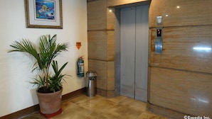 An elevator with a fire extinguisher and a fire warning sign on the wall.