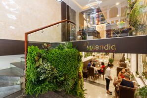 A modern interior with a staircase, a green wall with plants, and a restaurant named 'Splendid'. - Splendid Holiday Hotel (Hanoi)