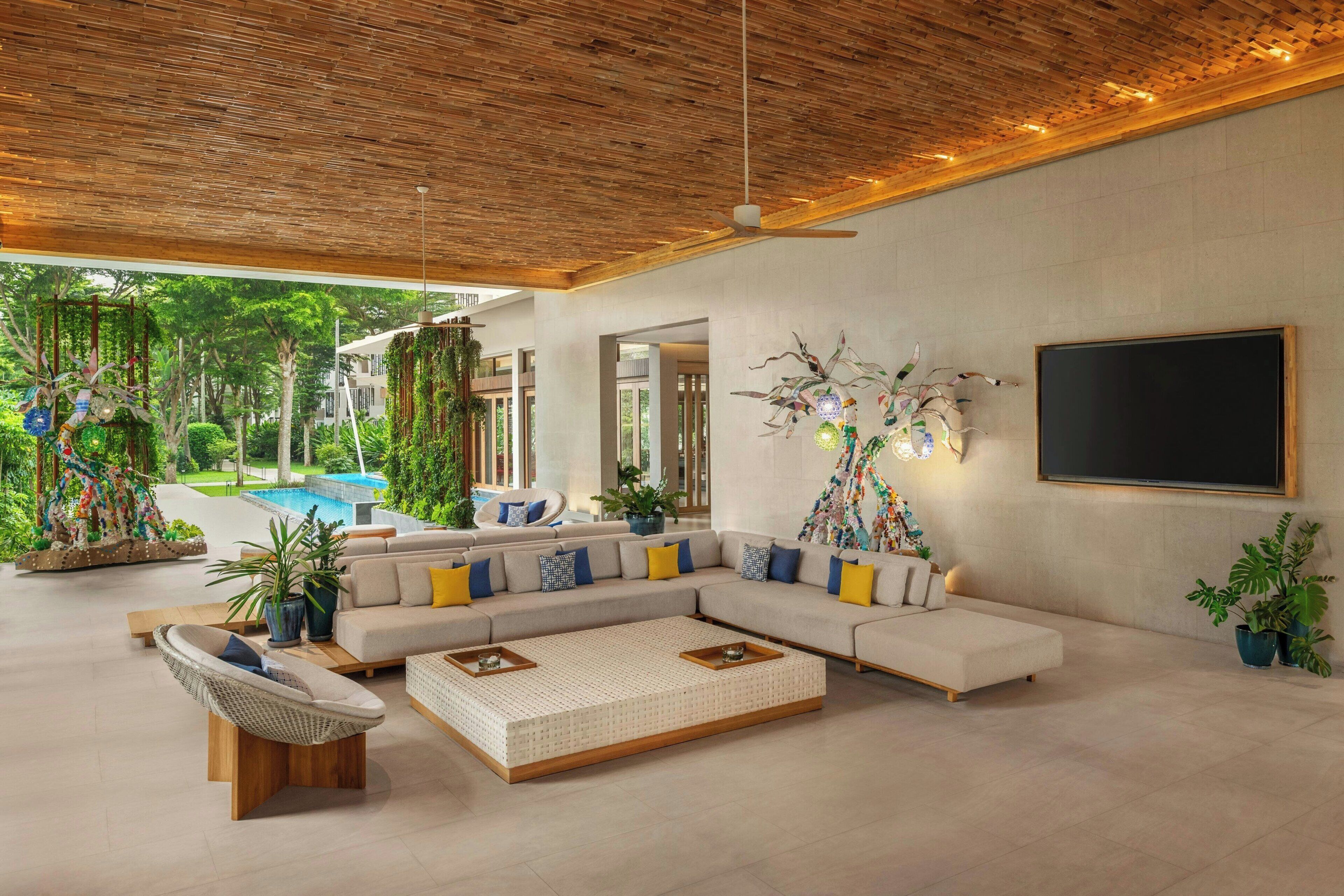 A modern living room with a sectional sofa, a coffee table, and a ceiling fan.