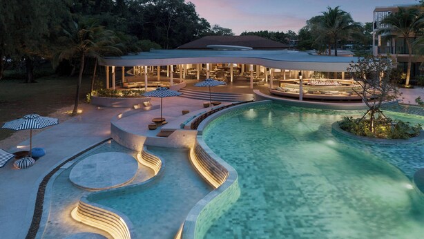Ein modernes Resort mit großem Pool, Außenbereich zum Sitzen und einer überdachten Lounge.