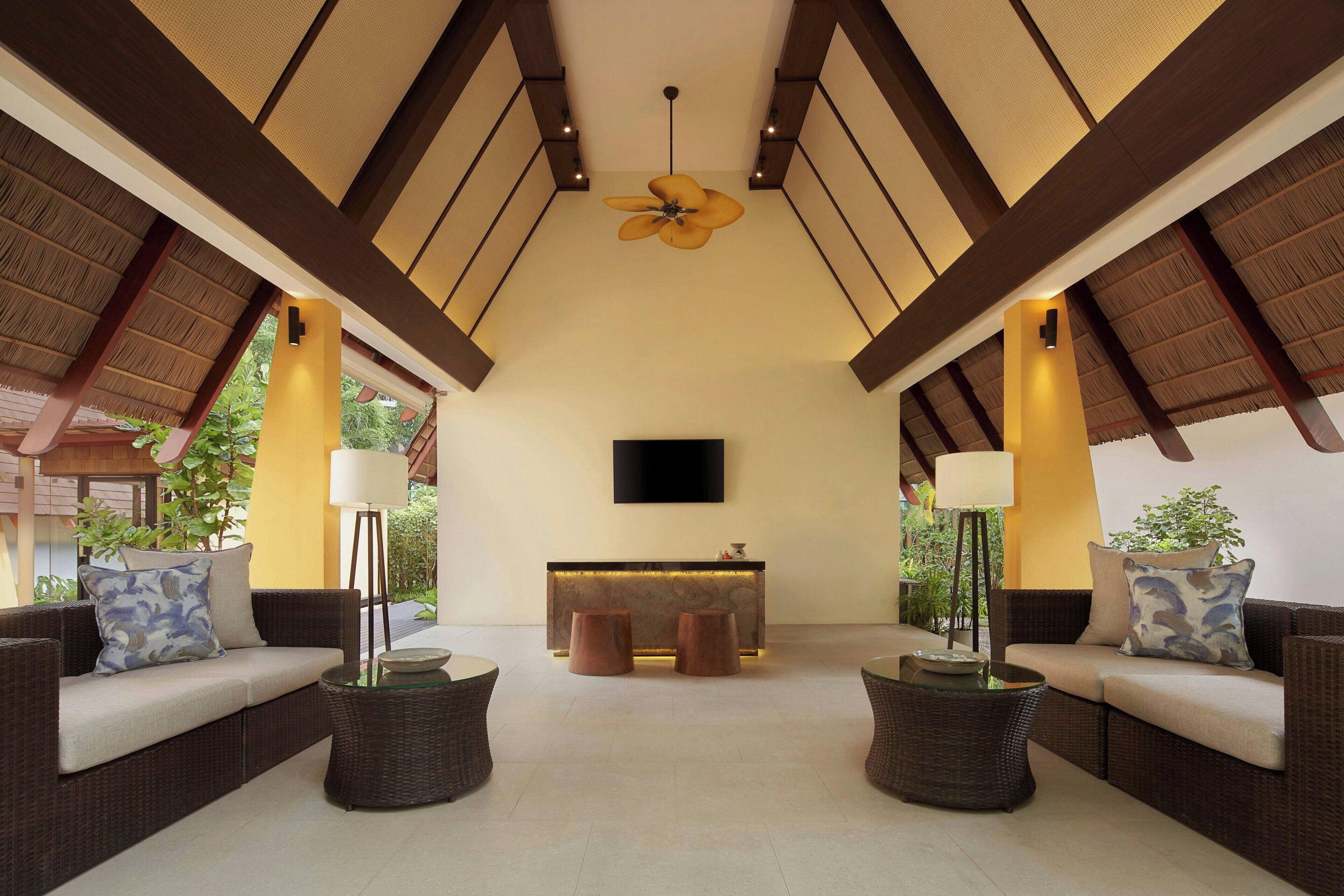 A spacious lounge area with a high ceiling, a central reception desk, and comfortable seating arrangements.