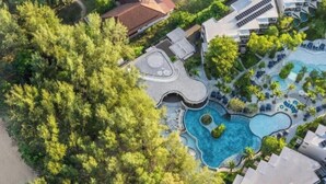 Ein Luftbild eines Resorts mit großem Pool, mehreren Gebäuden und üppiger Bepflanzung.