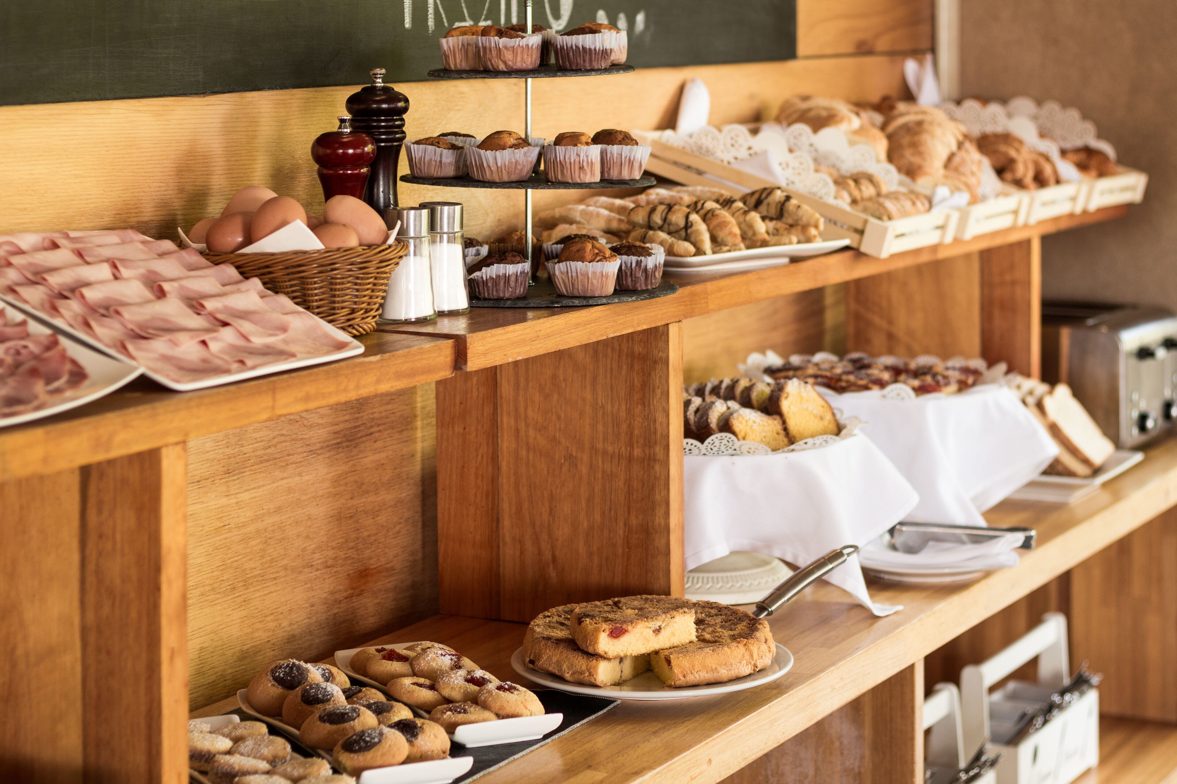 A buffet with various baked goods and pastries.