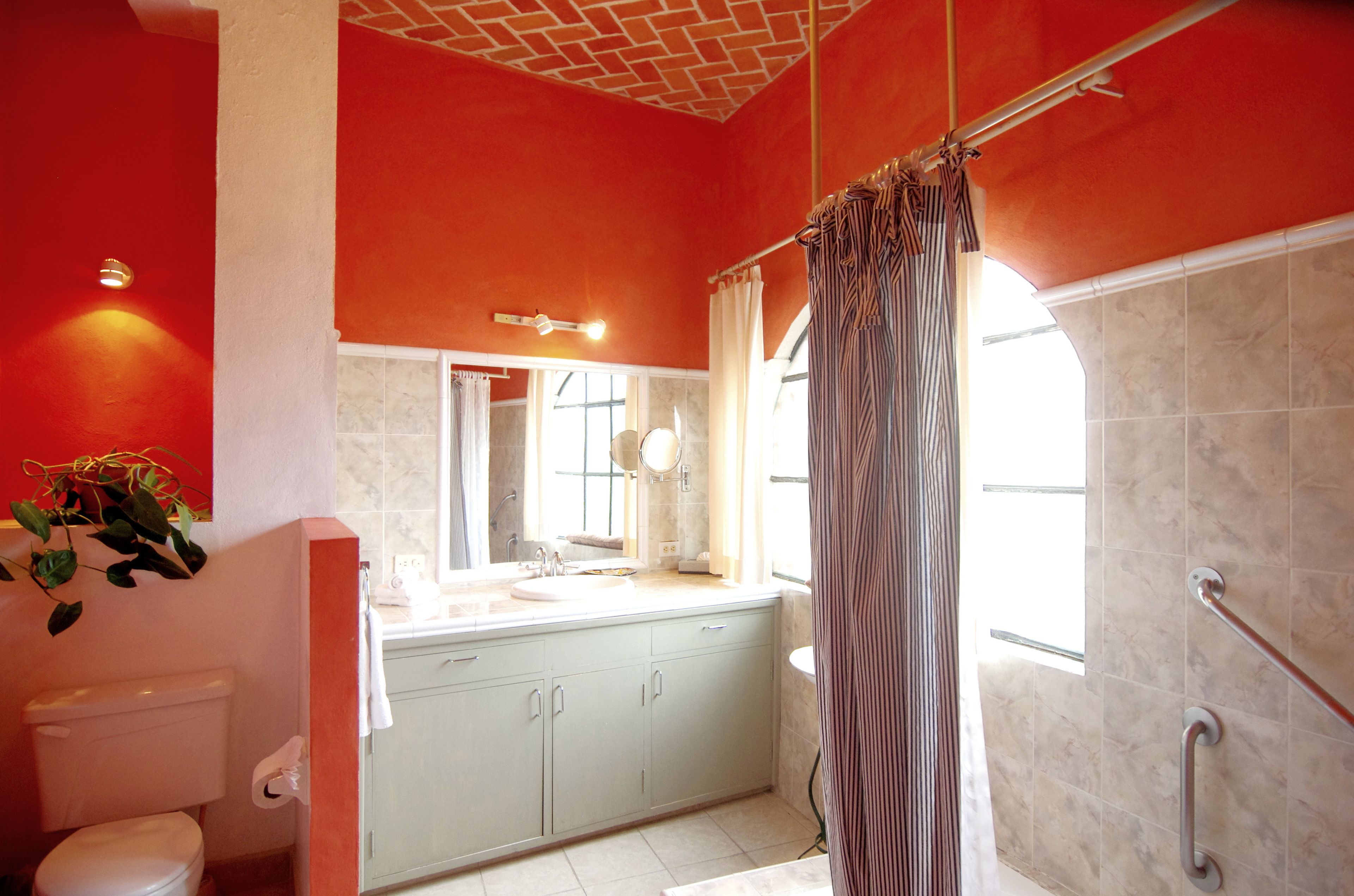 Un baño con inodoro, lavamanos y zona de ducha.