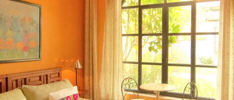 Una habitación con una cama, una ventana, una silla y una mesa.