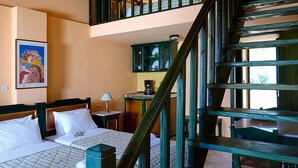 A room with a bed, a staircase, and a dining area.