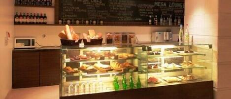 A dessert display case with various pastries and a chalkboard menu above it.