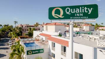 A hotel sign with "Quality Inn by Choice Hotels" and a rooftop pool area.