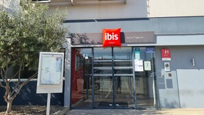 Um edifício moderno com a placa da rede ibis hotels.