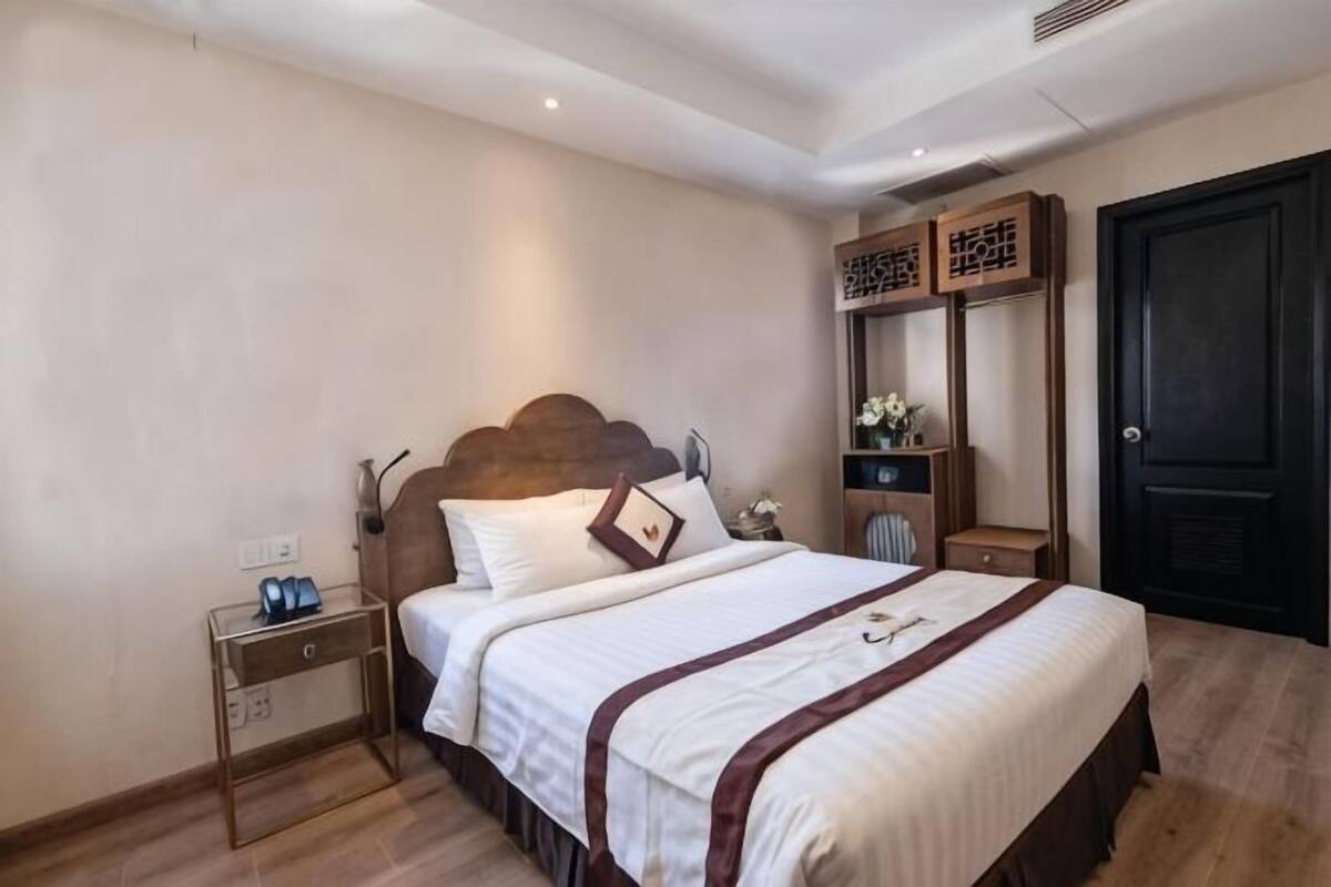 Een slaapkamer met een bed, nachtkastje en een kledingkast.