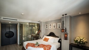A modern hotel room with a large bed, a glass shower enclosure, and a dark wooden wardrobe. - Sanouva Saigon Hotel (Ho Chi Minh City)