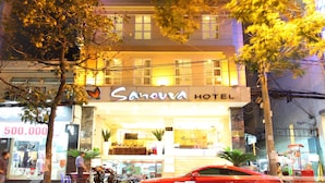 A hotel with a modern design, featuring multiple floors and illuminated windows. - Sanouva Saigon Hotel (Ho Chi Minh City)