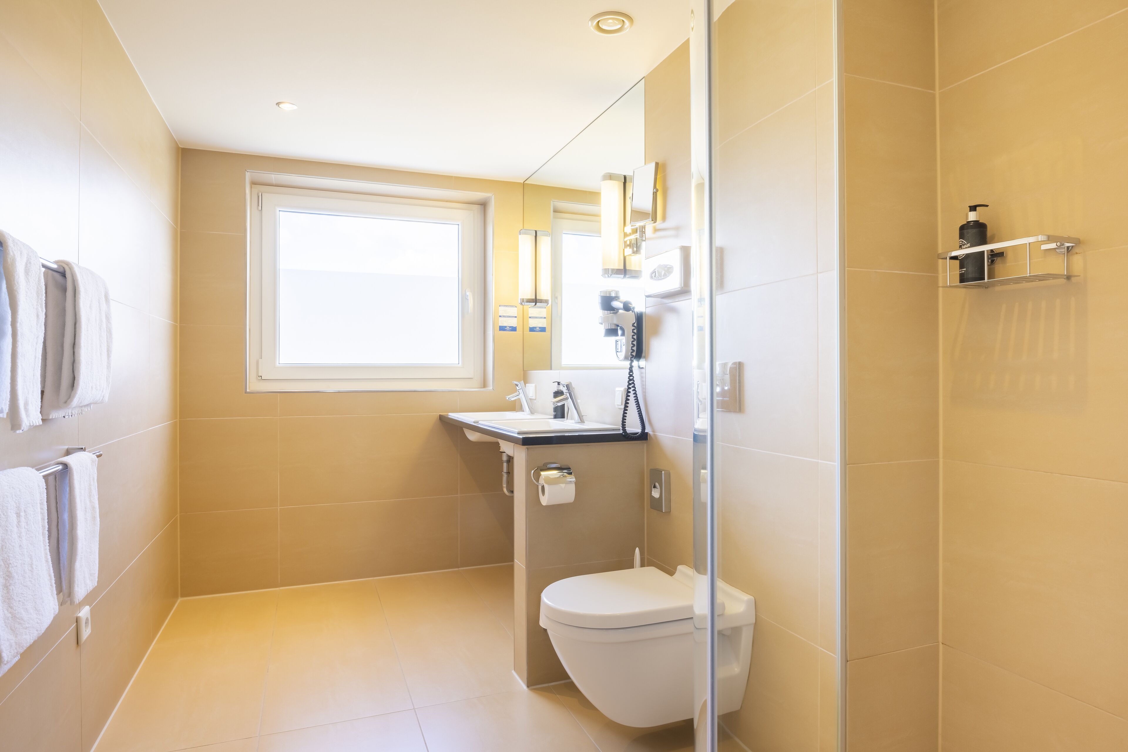 A modern bathroom with a toilet, sink, and shower area.