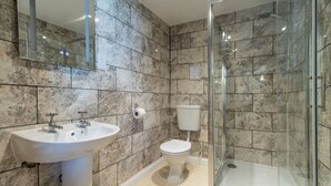 A bathroom with a sink, toilet, and glass-enclosed shower.