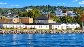 A motel with multiple rooms, a swimming pool, and a view of the water.