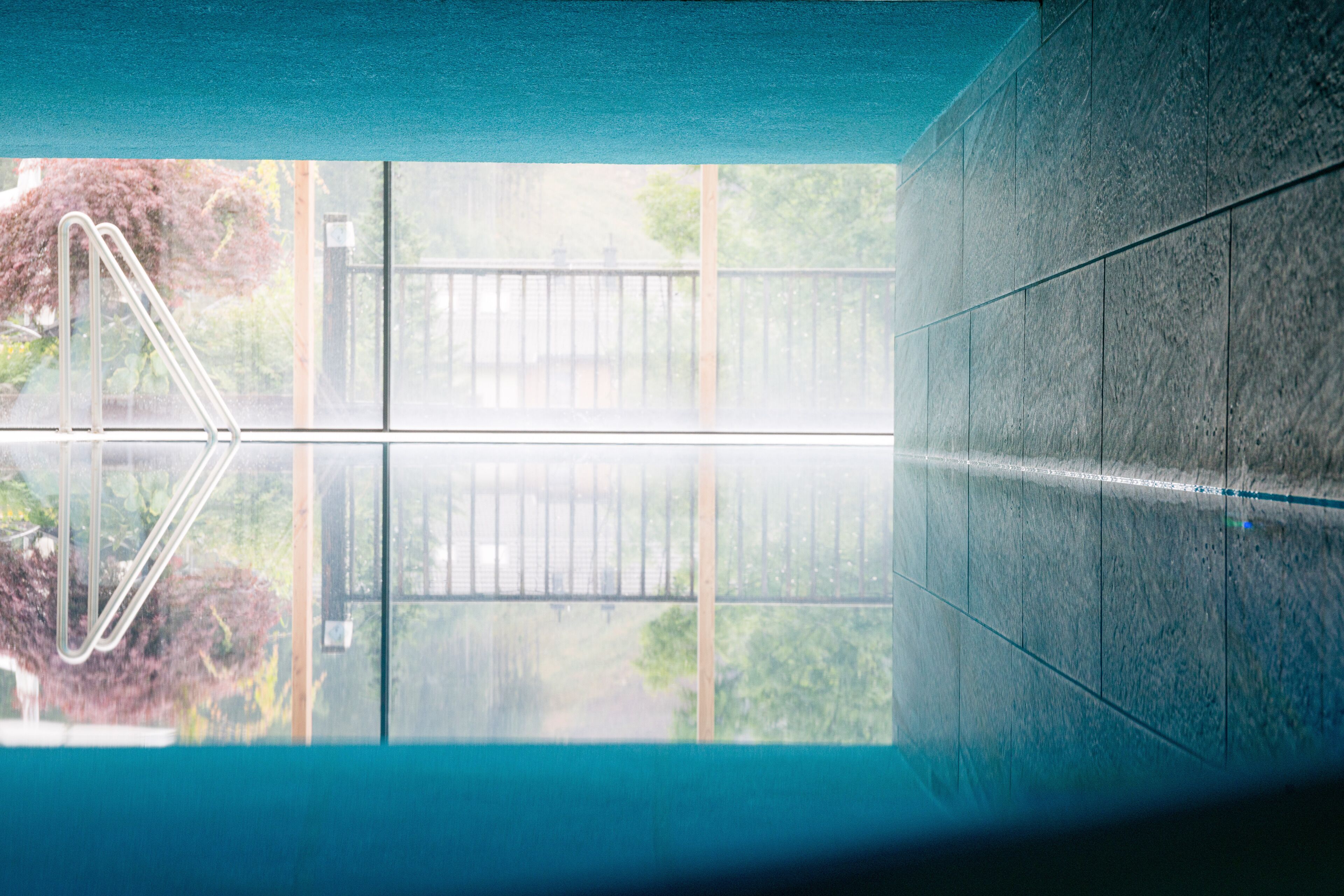 Ein Schwimmbecken mit Glasboden, das die Umgebung spiegelt und eine klare Sicht bietet.
