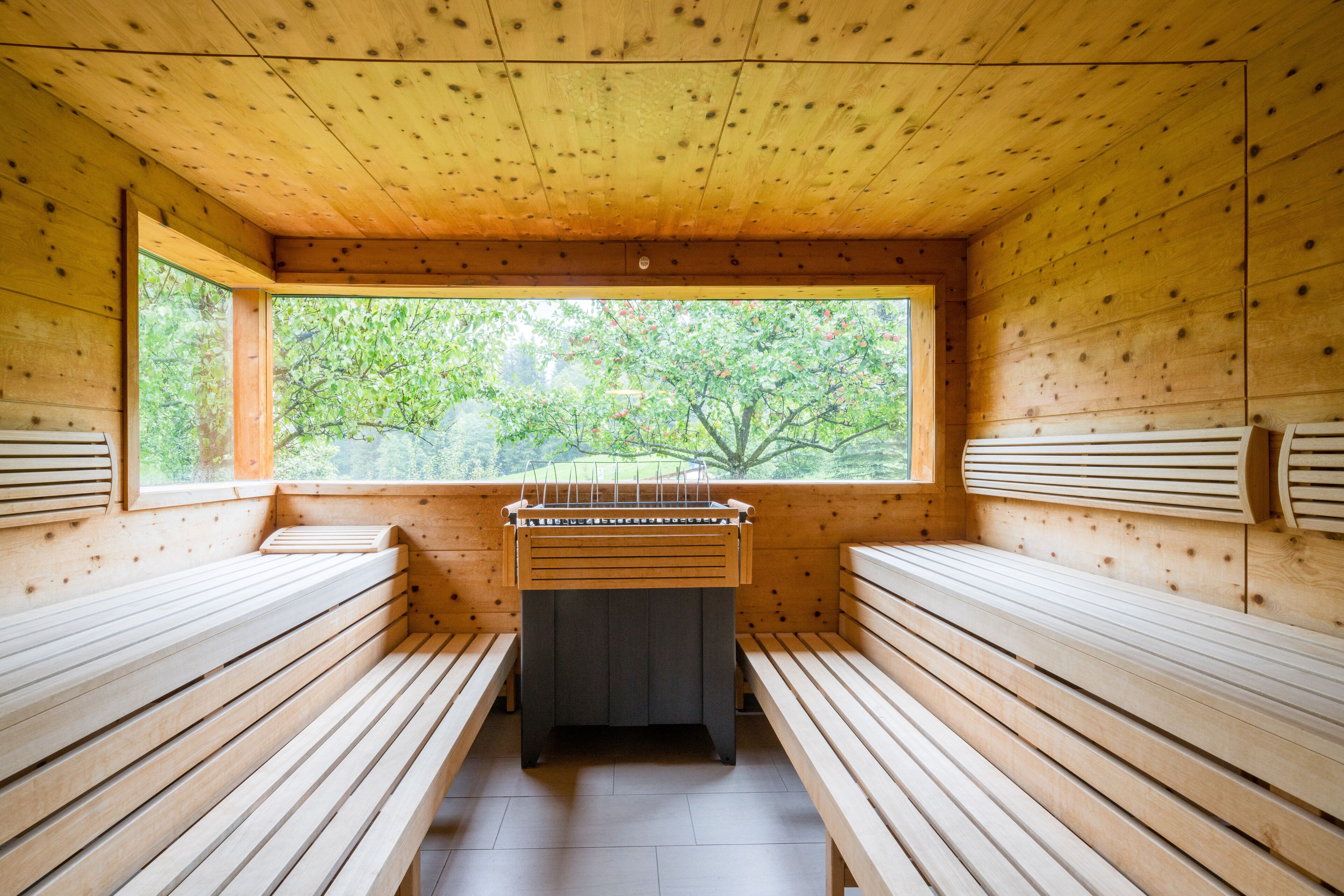 Un sauna con bancos de madera y un calentador.