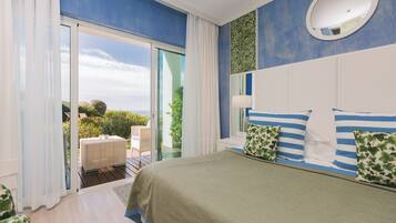 Quarto com cama grande, porta de correr para uma varanda e vista para o verde.