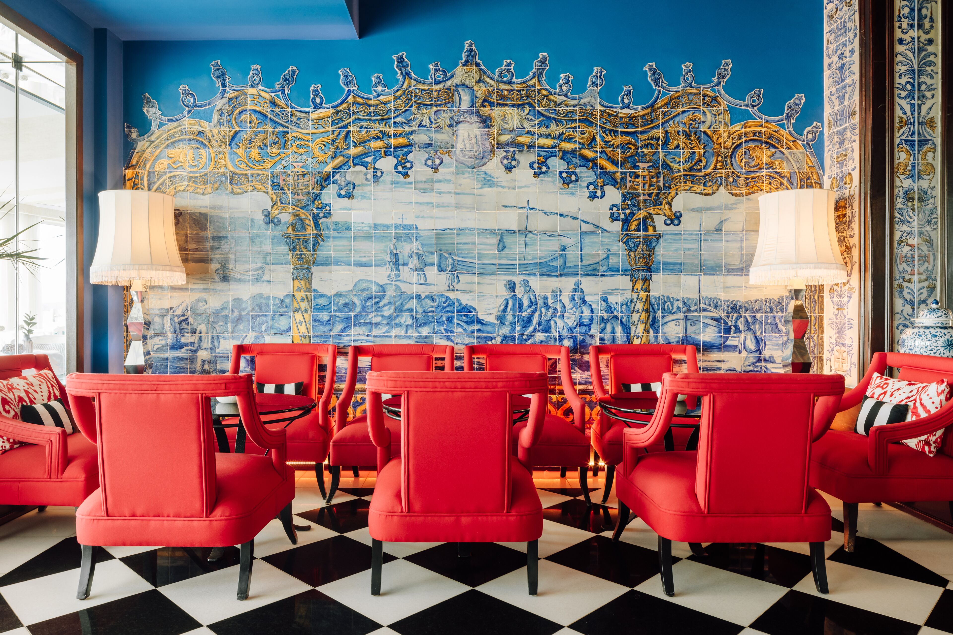 A room with red chairs arranged in front of a blue and gold tiled wall.