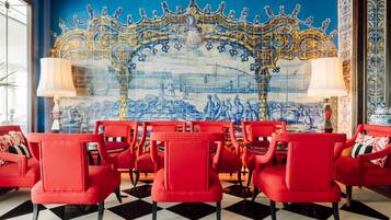 A room with red chairs arranged in front of a blue and gold tiled wall.