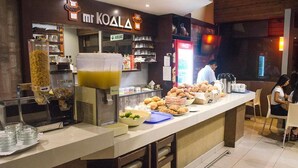 A breakfast bar with various food items and a coffee machine. - Hotel Kamana (Lima)
