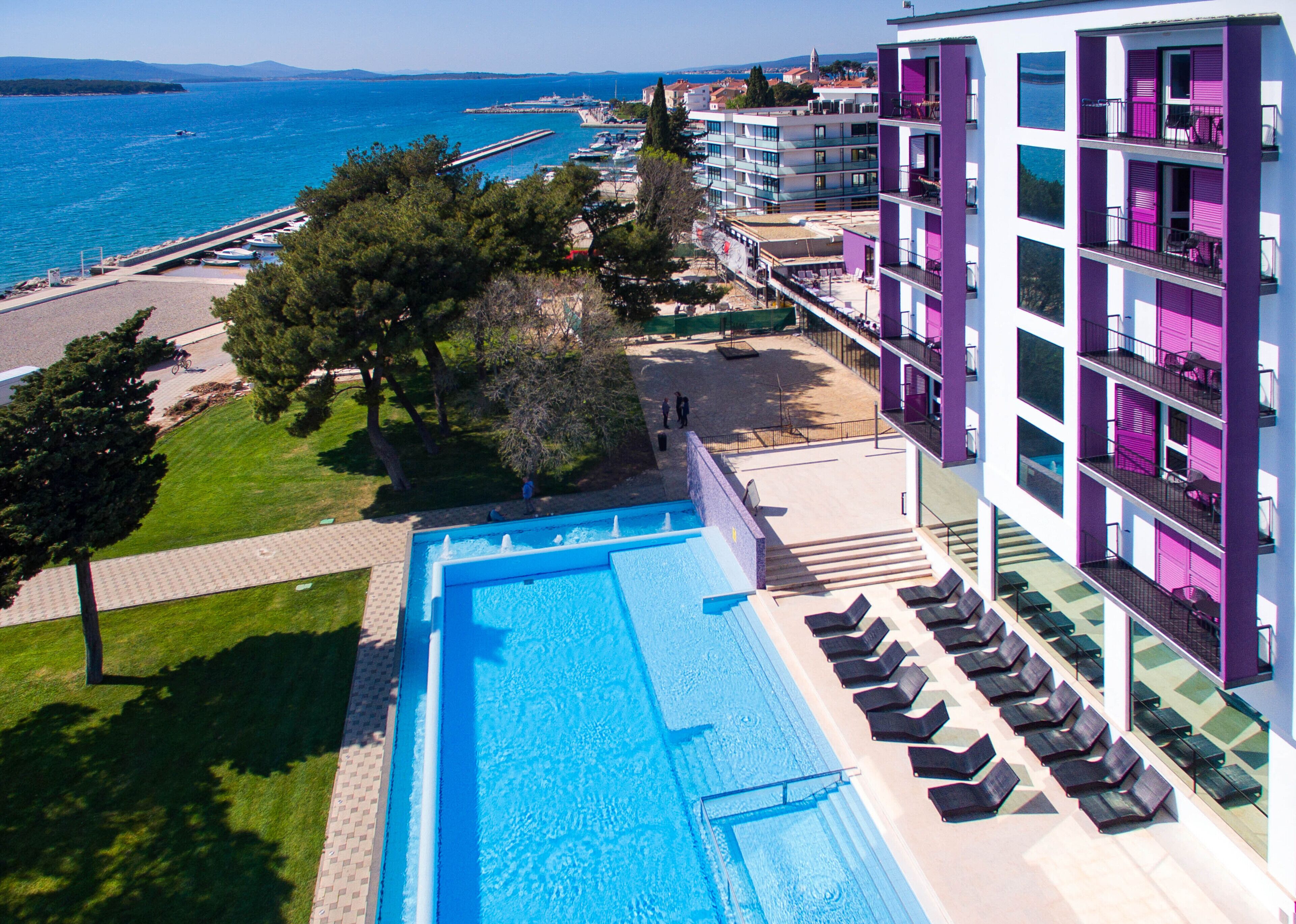 Un hotel con piscina, zona de estar al aire libre y vistas al mar.