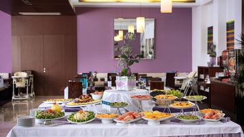 Ein reichhaltiges Buffet mit verschiedenen Speisen und einer Blumenvase.