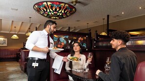 A restaurant with a waiter serving food to a table. - Seven Oaks Hotel with Heated Indoor Pool and Fitness Centre Carlow Town (Carlow)